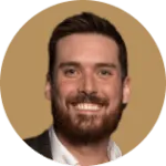 Professional headshot of smiling man with beard and dark hair on beige background