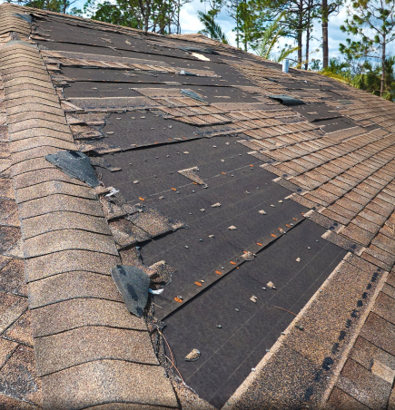 Damaged roof with missing shingles and exposed black underlayment needing repair