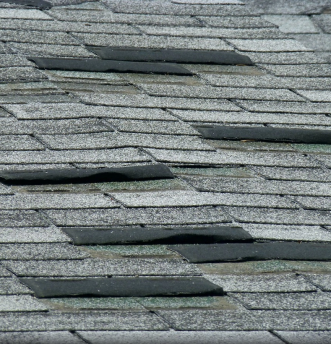 Weathered gray wooden roof shingles with natural wood grain texture and layers