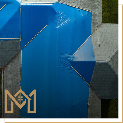 Aerial view of a roof covered with blue tarp for repair